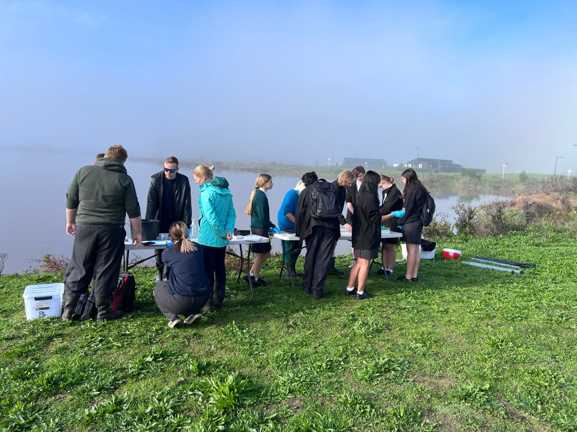 Students and volunteers testing water quality on the shore of Lake Waikare